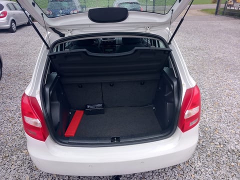 White car with open trunk showing empty black cargo space and red tailgate open in parking lot