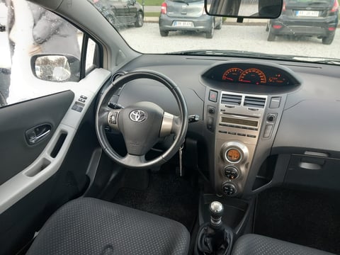 Interior view of Toyota car dashboard with steering wheel, instrument cluster, and center console while driving on highway