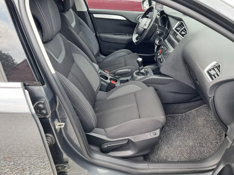Interior view of a compact car showing gray fabric seats, steering wheel, dashboard, and center console with manual transmission