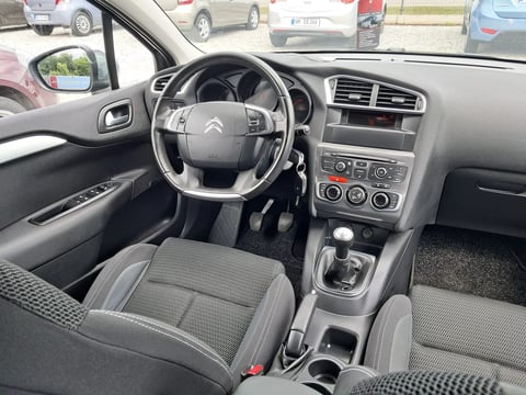 Interior view of a Citroen vehicle showing steering wheel, dashboard, gray seats, and center console with manual transmission